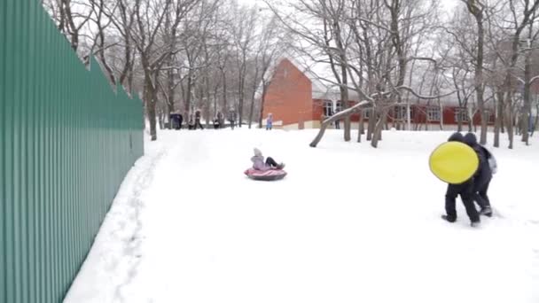 Crianças e adultos passeio de inverno em um trenó inflável e tubo — Vídeo de Stock