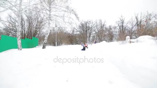 Enfants hiver traîneau en bas de la colline — Video