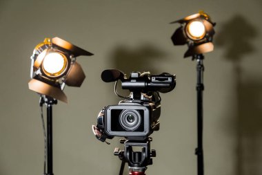 Camcorder and the two spotlights with Fresnel lenses. Filming in the interior or Studio clipart