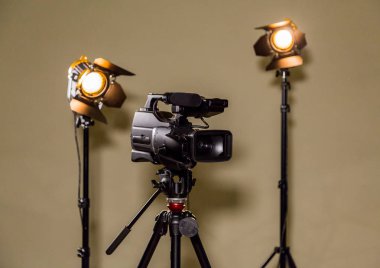 The camera and two floodlights to direct light. Artificial lighting in the interior or Studio for shooting. Fresnel lens and halogen bulb clipart
