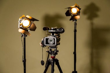 Camcorder and the two spotlights with Fresnel lenses. Filming in the interior or Studio clipart