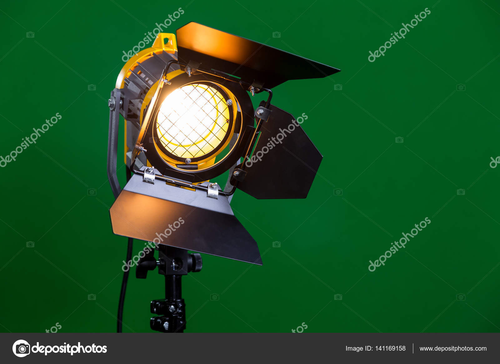Halogen spotlight with a Fresnel lens on green background close-up