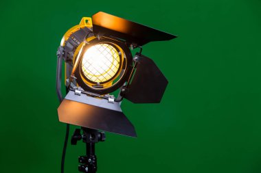 Halogen spotlight with a Fresnel lens on green background close-up. clipart