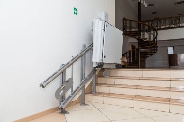 Stair lift for the disabled. Stairs of public building. clipart