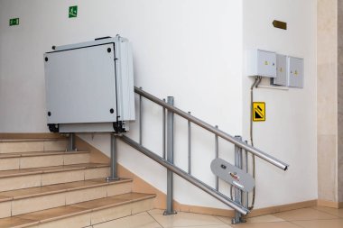 Stair lift for the disabled. Stairs of public building. clipart