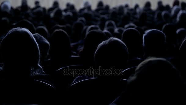 Gente en el auditorio mirando el escenario. Disparando por la espalda. Filmación — Vídeos de Stock