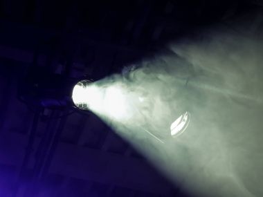 The beam from a searchlight through smoke. Lighting equipment on the ceiling. The stage of a theatre or night club. Show or performance. clipart