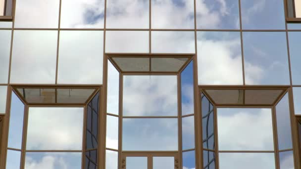 Floating in the sky clouds reflected in the Windows of the building. Time-lapse recording — Stock Video