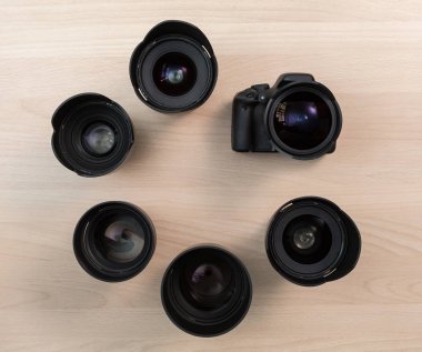 Dijital Slr fotoğraf makinesi ve birkaç değiştirilebilir manuel lensler. Film yapım donatımı. Ahşap masa