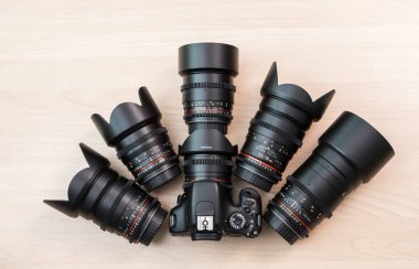 Dijital Slr fotoğraf makinesi ve birkaç değiştirilebilir manuel lensler. Film yapım donatımı. Ahşap masa