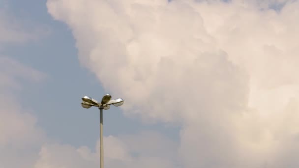 Lamppost against the sky. Clouds running through blue sky. Time-lapse recording. A looped clip with no breaks — Stock Video