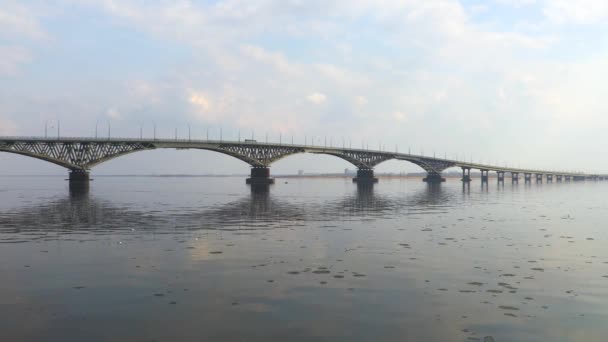 De verkeersbrug tussen de steden van Saratov en Engels. Een rivierlandschap. Lente. De drift van het ijs op de rivier. Rusland, Saratov, de Wolga. Beeldmateriaal in 4k Uhd — Stockvideo