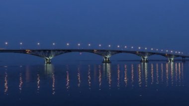 Dolunay üzerinde köprü yükselir. Hızlandırılmış. Saratov şehirler ve Engels, Rusya arasındaki yolu köprüsü. Volga Nehri. Arabalar ve sokak ışıkları gece ışıkları. 4k, Ultra Hd