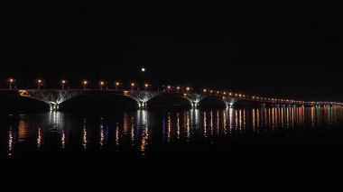 Dolunay üzerinde köprü yükselir. Saratov şehirler ve Engels, Rusya arasındaki yolu köprüsü. Volga Nehri. Arabalar ve sokak ışıkları akşam ışıklar