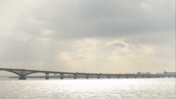 Vägen överbryggar över floden Volga mellan städerna Saratov och Engels, Ryssland. Landskap med en flod, moln på himlen. Tid förflutit. 4k Ultra Hd, Uhd — Stockvideo
