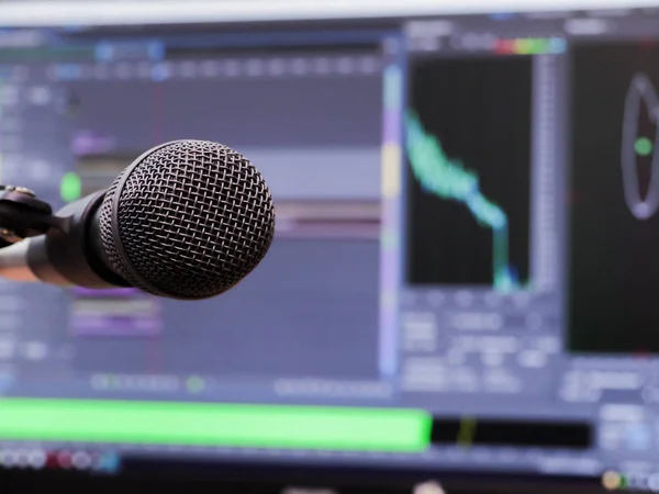 Microphone on the background of the computer monitor. Home recording Studio. Close-up. The focus in the foreground. Blurred background. Software for recording and editing sounds
