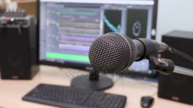 Mikrofon bilgisayar monitörü arka plan üzerinde. Ev kayıt stüdyosu. Yakın çekim. Odağı ön planda. Arka plan bulanık. Kayıt ve düzenleme sesler için yazılım. 4k, Uhd, Ultra Hd