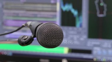 Mikrofon bilgisayar monitörü arka plan üzerinde. Ev kayıt stüdyosu. Yakın çekim. Odağı ön planda. Arka plan bulanık. Kayıt ve düzenleme sesler için yazılım. 4k, Uhd, Ultra Hd