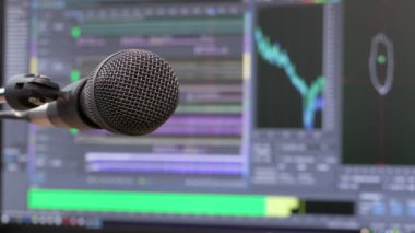 Mikrofon bilgisayar monitörü arka plan üzerinde. Ev kayıt stüdyosu. Yakın çekim. Odağı ön planda. Arka plan bulanık. Kayıt ve düzenleme sesler için yazılım. 4k, Uhd, Ultra Hd