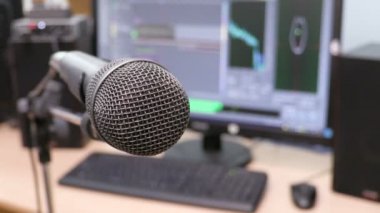 Mikrofon bilgisayar monitörü arka plan üzerinde. Ev kayıt stüdyosu. Yakın çekim. Odağı ön planda. Arka plan bulanık. Kayıt ve düzenleme sesler için yazılım. 4k, Uhd, Ultra Hd