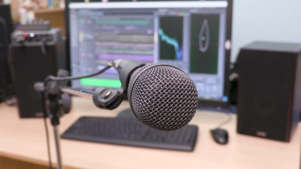 Microphone on the background of the computer monitor. Home recording Studio. Close-up. The focus in the foreground. Blurred background. Software for recording and editing sounds. 4K, UHD, Ultra HD — Stock Video