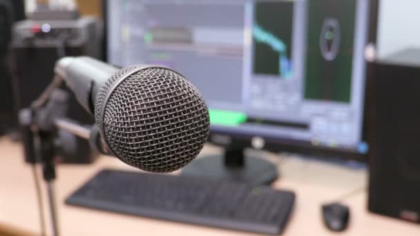 Microphone on the background of the computer monitor. Home recording Studio. Close-up. The focus in the foreground. Blurred background. Software for recording and editing sounds. 4K, UHD, Ultra HD — Stock Video