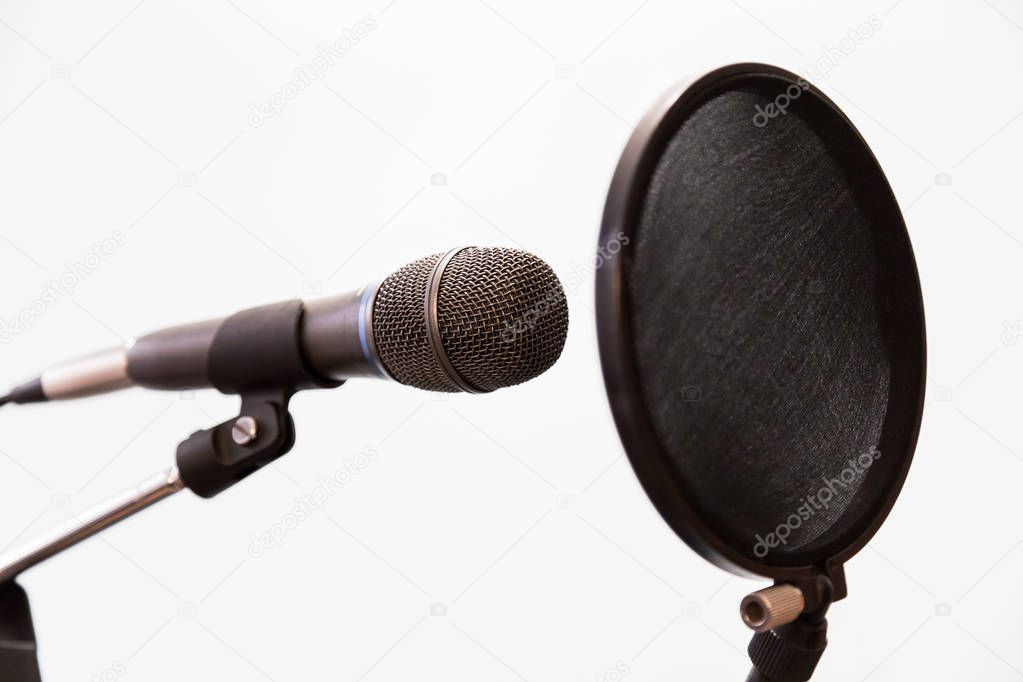 Cardioid condenser microphone and pop filter on a gray background. Home recording Studio.