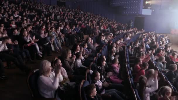 Kinderen in de zaal applaudisseren bij de uitvoering. Theater voor jonge toeschouwers, Rusland, Saratov, 28 April 2017 — Stockvideo