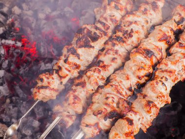 Kömürlerin üzerinde kebap yemek. Şiş üzerinde ızgara domuz