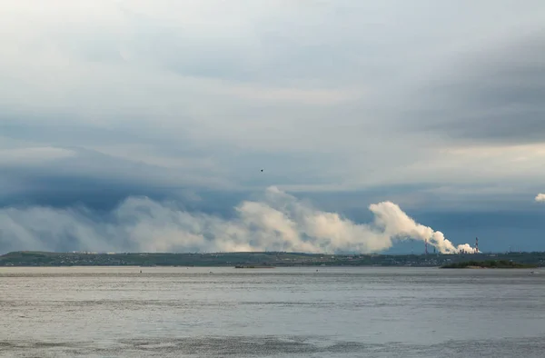 A vista do rio Volga no distrito de Fábrica da cidade de Saratov. A Rússia. Uma paisagem fluvial. Tubo de fábrica. Poluição ambiental, emissões para a atmosfera. O céu e as nuvens — Fotografia de Stock