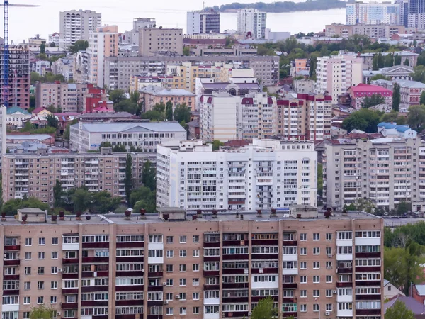 Vista della città di Saratov dalla montagna. Il paesaggio urbano, le infrastrutture, le case popolari, gli edifici pubblici e le strade, il fiume Volga all'orizzonte. Provincia russa — Foto Stock