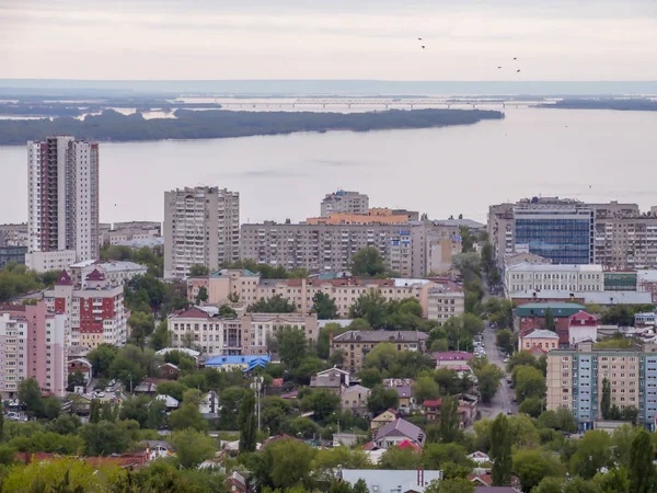 El horizonte de la ciudad. La provincia rusa de Saratov. Edificios residenciales de gran altura, el río Volga y el puente ferroviario en el horizonte — Foto de Stock