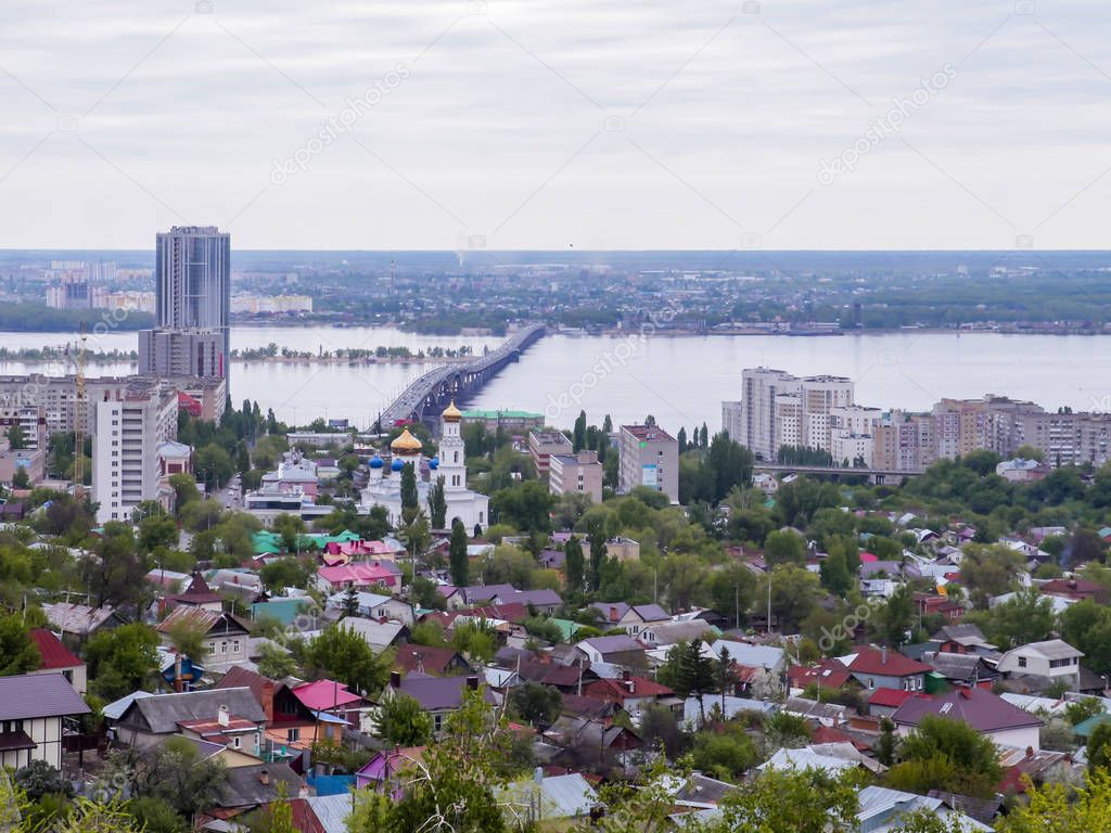 Road bridge across the Volga river between the cities of Saratov and Engels. The city's skyline. An Orthodox Church. May