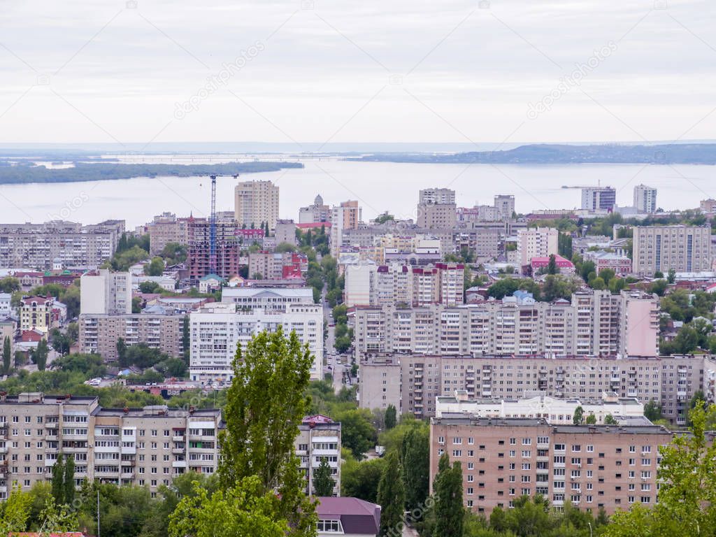 The city's skyline. The Russian province of Saratov. High-rise residential buildings, the Volga river and the railway bridge on the horizon