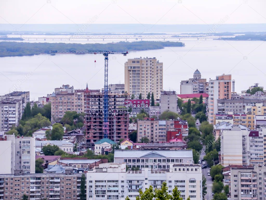 The city's skyline. The Russian province of Saratov. High-rise residential buildings, the Volga river and the railway bridge on the horizon