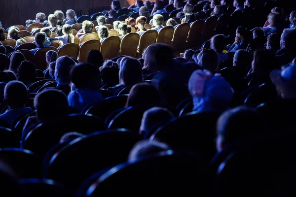 Mensen, kinderen, volwassenen, ouders in het theater, kijken naar de prestaties. Mensen in de zaal kijken naar het werkgebied. Schieten vanaf de achterkant — Stockfoto