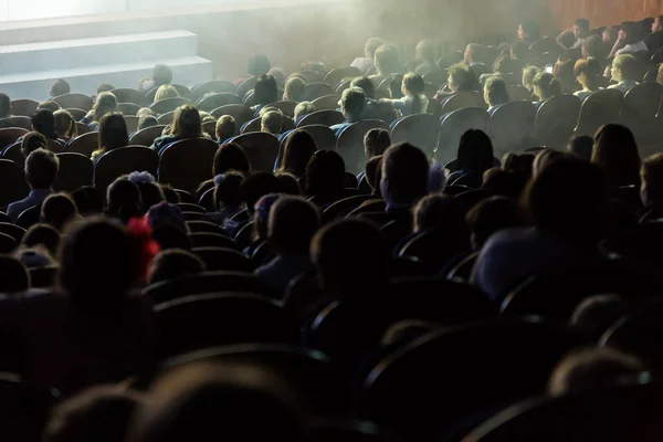 Mensen, kinderen, volwassenen, ouders in het theater, kijken naar de prestaties. Mensen in de zaal kijken naar het werkgebied. Schieten vanaf de achterkant — Stockfoto