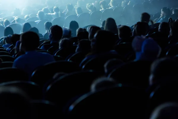 Pessoas, crianças, adultos, pais no teatro assistindo a performance. Pessoas no auditório a olhar para o palco. Tiroteio pelas costas — Fotografia de Stock