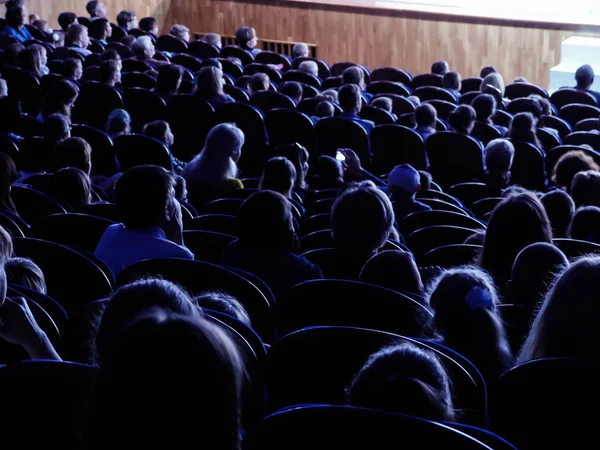 Mensen, kinderen, volwassenen, ouders in het theater, kijken naar de prestaties. Mensen in de zaal kijken naar het werkgebied. Schieten vanaf de achterkant — Stockfoto