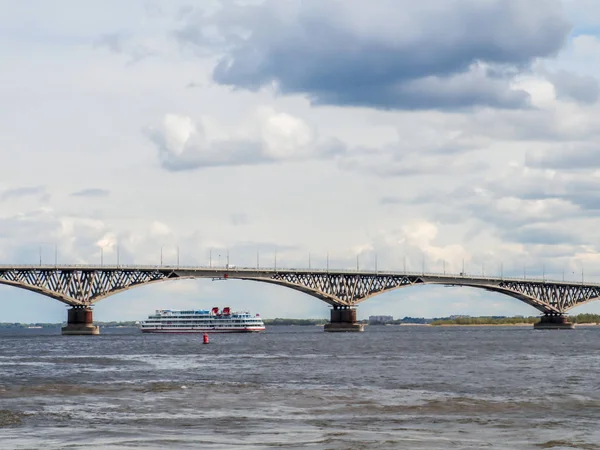 El barco de pasajeros de cuatro pisos pasa por debajo del puente de carretera. Rusia, ciudad Saratov — Foto de Stock