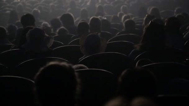 Os espectadores assistem ao espetáculo ou à vista no teatro. Vídeo lá atrás. Crianças e adultos — Vídeo de Stock