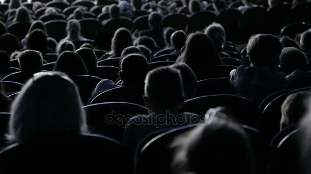Os espectadores assistem ao espetáculo ou à vista no teatro. Vídeo lá atrás. Crianças e adultos — Vídeo de Stock