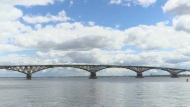 Volga Nehri Saratov şehirler ve Engels arasında yol köprüden. Zaman atlamalı nehir sahne. Gökyüzünde yüzen. Köprüde araçların hareketi. Yaz günü. Rusya