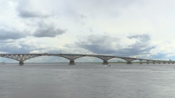 Pasajeros de tres pisos barco a motor pasa por debajo de un puente de carretera a través del río Volga. Grabación de lapso de tiempo. Día de verano. Rusia, ciudad Saratov. Imágenes de clip en 4K — Vídeos de Stock