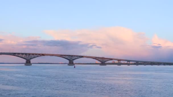 Timelapse van een verkeersbrug over de Wolga tussen de steden van Saratov en Engels bij zonsondergang. Blauwe lucht en de roze wolken — Stockvideo