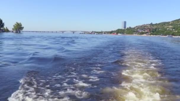 Riprese dalla poppa della nave. Paesaggio fluviale estivo. Il fiume Volga a Saratov, Russia. Ponte stradale tra le città di Saratov ed Engels. Il rumore del motore della barca. Clip di ripresa 4K — Video Stock