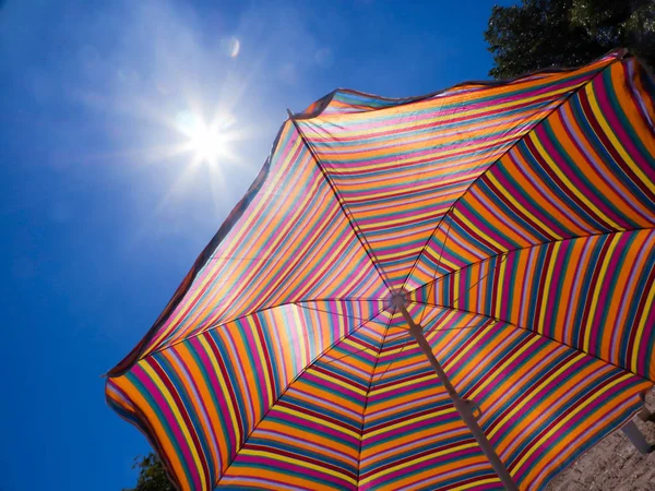 Färgglad Randig Parasoll Mot Himlen Och Solen Varmt Väder Strandsemester — Stockfoto