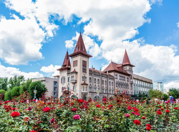 Staatliches Konservatorium Saratow. wurde 1912 in Russland eröffnet. blühende Rosen im Vordergrund. Wolken am blauen Himmel — Stockfoto