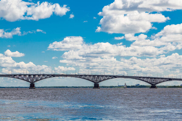 Дорожный мост через Волгу между городами Саратов и Энгельс, Россия. Летний речной пейзаж. Голубое небо, белые облака Лицензионные Стоковые Изображения