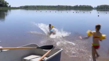 İki kız nehirde Yüzme bir yaz gününde yedi-dokuz yıl. Görüntüleri klip 4k, Ultra Hd. turist temel 